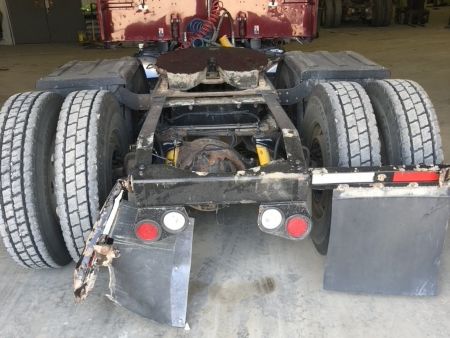 Rear wheels of semi truck showing a broken mudflap bar